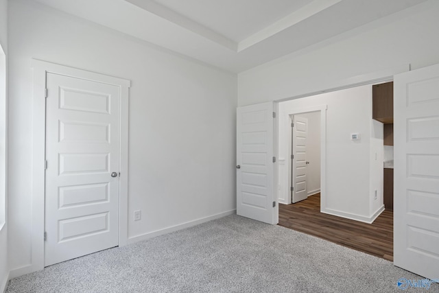 unfurnished bedroom featuring carpet floors and baseboards