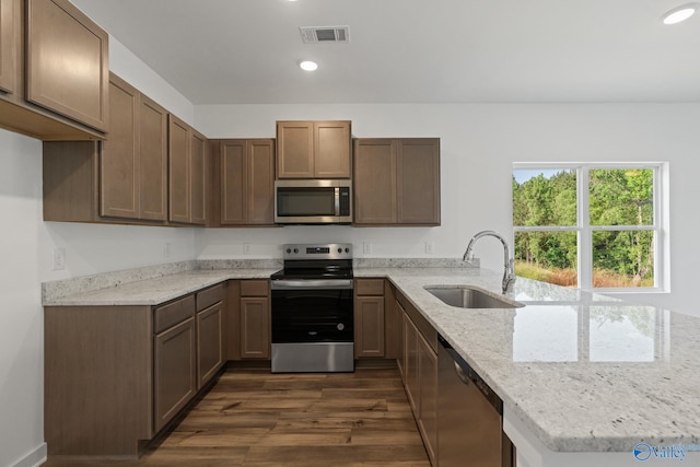 kitchen featuring stainless steel appliances, recessed lighting, visible vents, a sink, and a peninsula