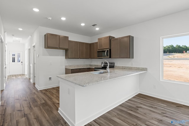 kitchen with recessed lighting, a peninsula, a sink, visible vents, and stainless steel microwave