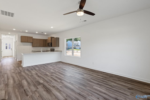 unfurnished living room featuring baseboards, visible vents, dark wood finished floors, and recessed lighting