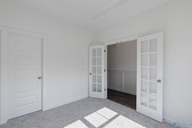 unfurnished bedroom with carpet floors, french doors, and baseboards