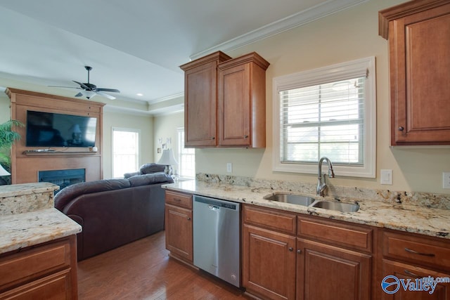 kitchen featuring crown molding, dark hardwood / wood-style flooring, sink, a large fireplace, and stainless steel dishwasher