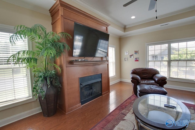 living room with ornamental molding, hardwood / wood-style floors, and ceiling fan