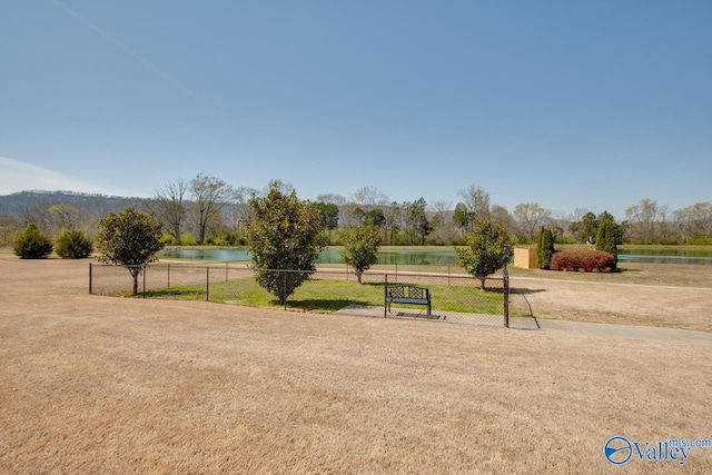 surrounding community with a water view and a lawn