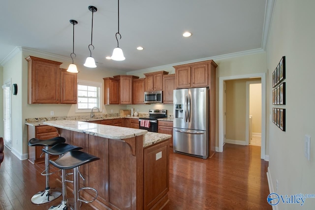 kitchen with stainless steel appliances, a kitchen island, dark hardwood / wood-style floors, pendant lighting, and sink