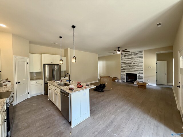 1112 Mountainview Rd NE, Hartselle, AL 35640 - kitchen featuring stainless steel appliances, a sink, ceiling fan, white cabinets, and a large fireplace
