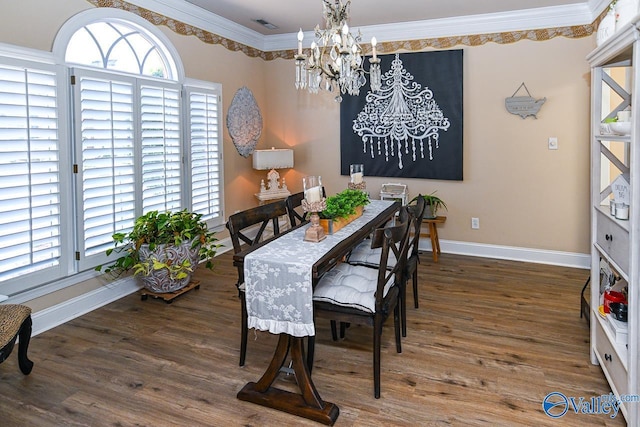 dining room with an inviting chandelier, baseboards, crown molding, and wood finished floors