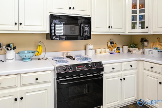 kitchen featuring black appliances, light countertops, glass insert cabinets, and white cabinets