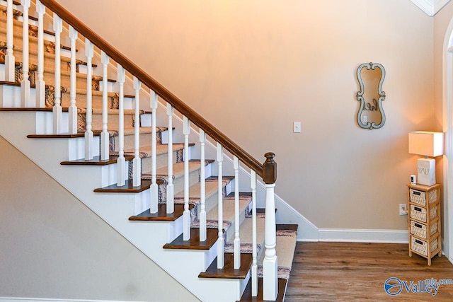 stairs with wood finished floors and baseboards