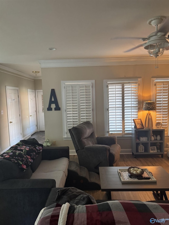 living room featuring crown molding, baseboards, and wood finished floors