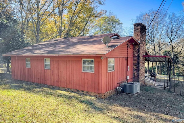 view of side of home with a yard and central AC unit