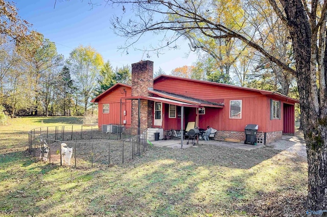 rear view of property featuring a patio area and a lawn