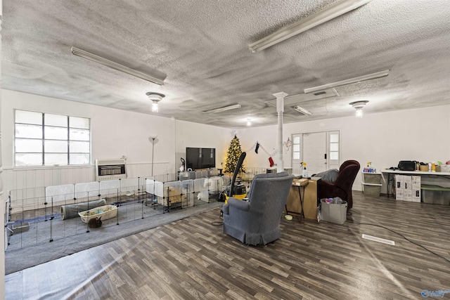 miscellaneous room with heating unit, dark hardwood / wood-style floors, and a textured ceiling