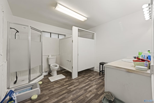 bathroom with toilet, vanity, wood-type flooring, and a shower with shower door