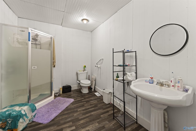 bathroom featuring toilet, wooden walls, hardwood / wood-style flooring, and walk in shower