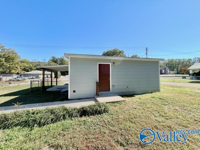 view of outdoor structure featuring fence and an outbuilding