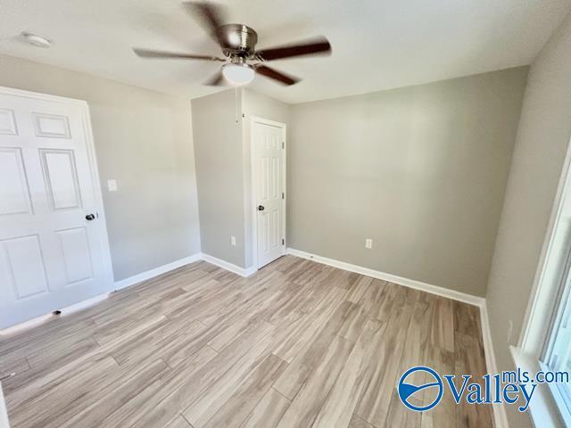 unfurnished bedroom featuring baseboards, ceiling fan, and light wood finished floors