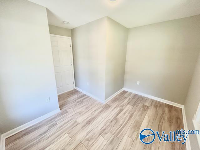 empty room featuring light wood-type flooring and baseboards