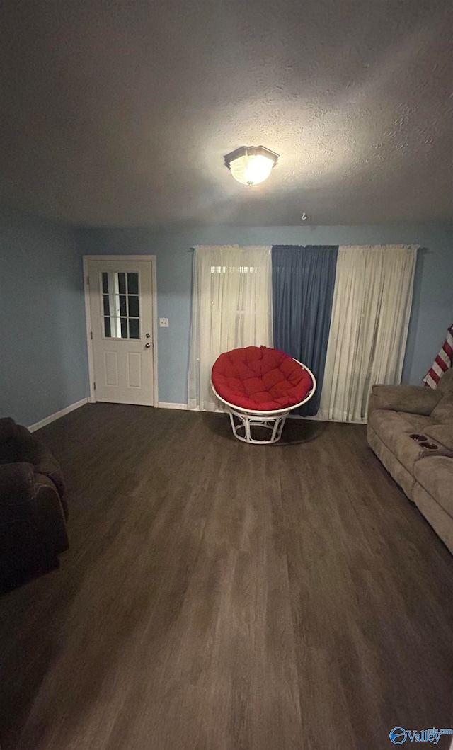 living area with hardwood / wood-style flooring and a textured ceiling