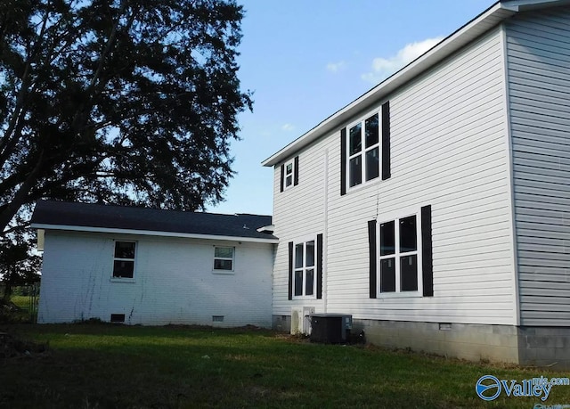 back of house with a lawn and central air condition unit