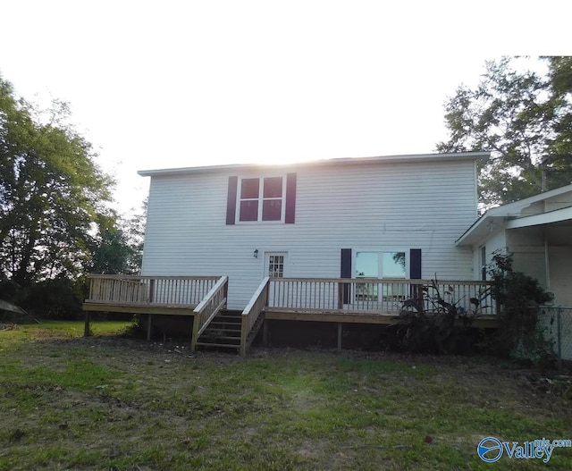 rear view of property with a deck and a yard