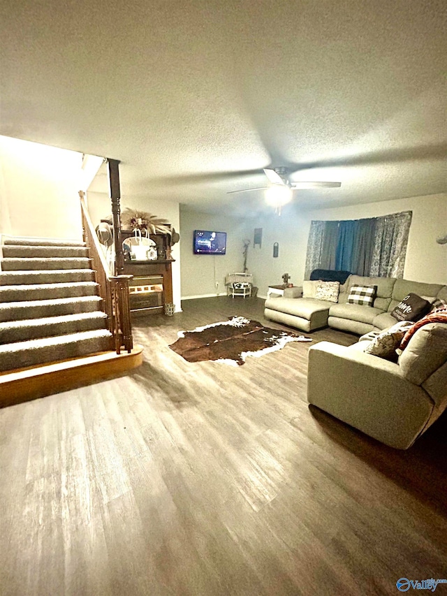 living room with ceiling fan, hardwood / wood-style floors, and a textured ceiling