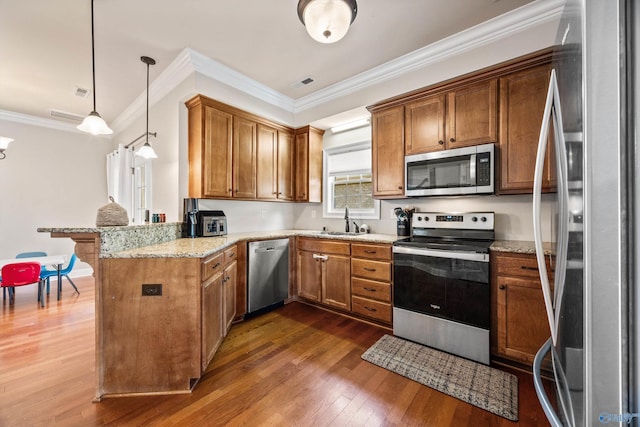 8 Cypress Point Dr, Huntsville, AL 35824 - kitchen with stainless steel appliances, a peninsula, a sink, brown cabinetry, and dark wood-style floors