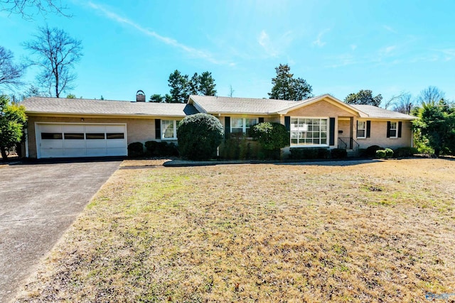 single story home featuring a garage, driveway, a chimney, and a front yard