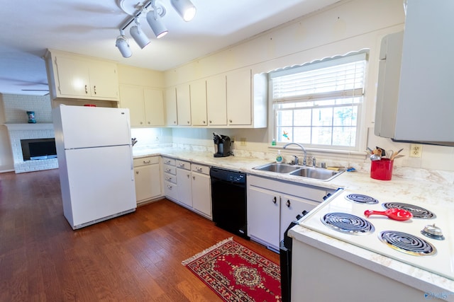 kitchen featuring white appliances, dark wood finished floors, light countertops, a fireplace, and a sink