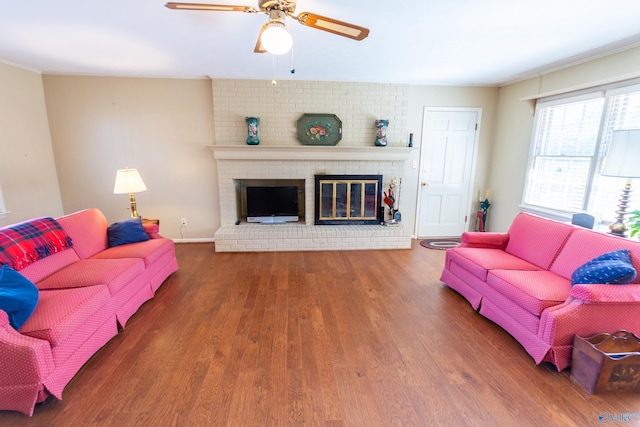 living area with ceiling fan, a fireplace, baseboards, and wood finished floors