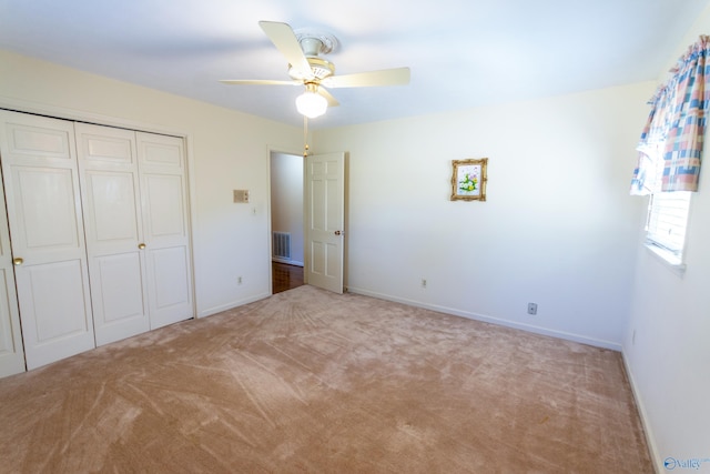 unfurnished bedroom featuring baseboards, visible vents, ceiling fan, carpet floors, and a closet