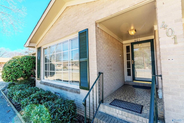 entrance to property featuring brick siding and crawl space