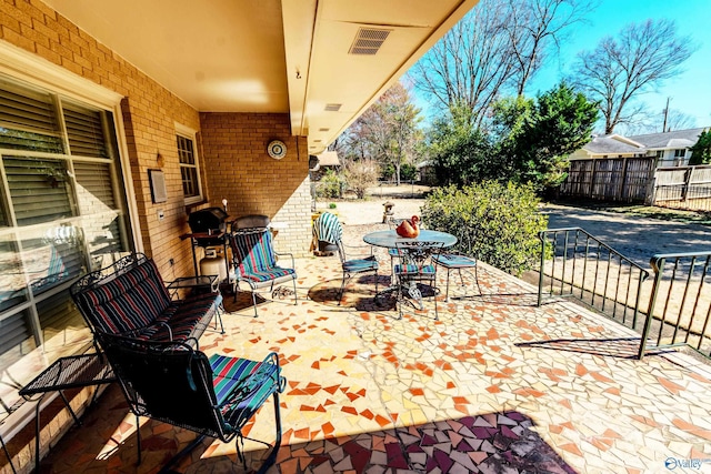 view of patio / terrace featuring fence and visible vents