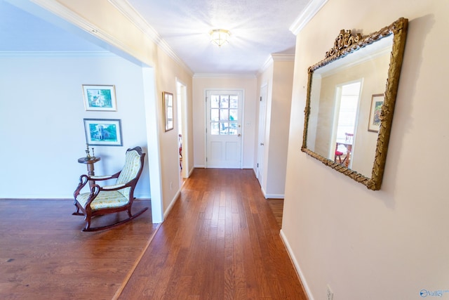 entryway with crown molding, dark wood finished floors, and baseboards