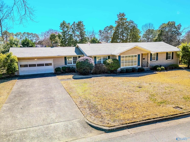 ranch-style house with a garage, a front yard, and aphalt driveway