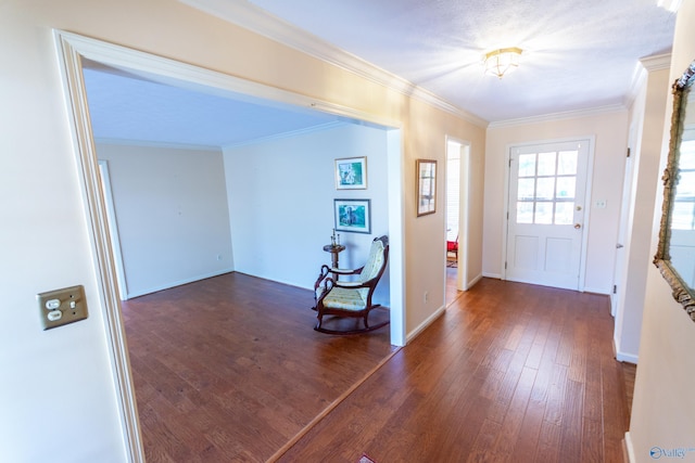 entrance foyer with wood-type flooring, baseboards, and crown molding