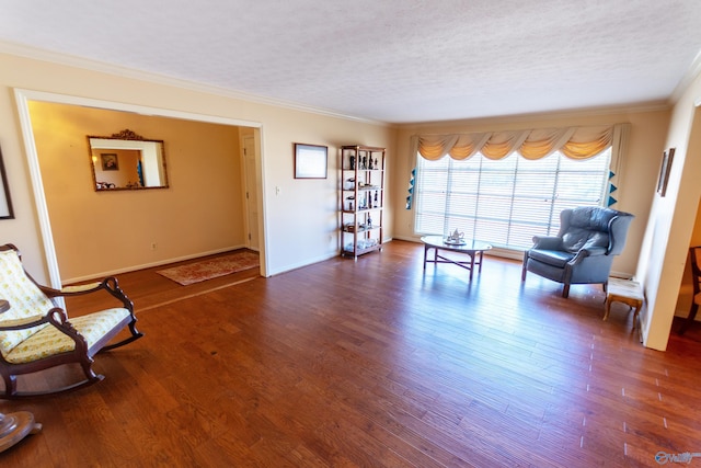 sitting room with a textured ceiling, ornamental molding, and wood finished floors