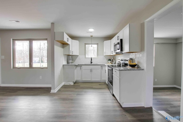 kitchen featuring decorative backsplash, stainless steel appliances, pendant lighting, white cabinets, and dark hardwood / wood-style floors