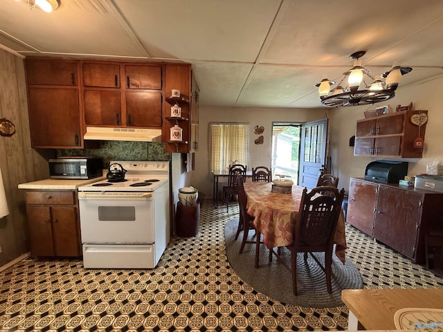 4094 County Road 66, Section, AL 35771 - kitchen with white electric range, under cabinet range hood, stainless steel microwave, a chandelier, and light countertops