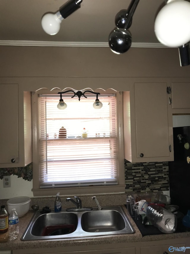 3411 Euclid Dr NW, Huntsville, AL 35810 - kitchen featuring a sink, ornamental molding, plenty of natural light, white cabinetry, and tasteful backsplash