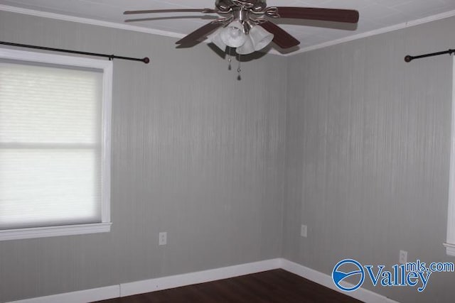 empty room with crown molding, ceiling fan, a barn door, and dark hardwood / wood-style flooring