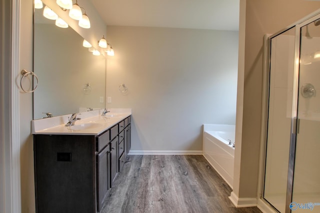 13971 Lannister Ln, Athens, AL 35613 - full bathroom featuring double vanity, wood finished floors, a garden tub, a shower stall, and baseboards