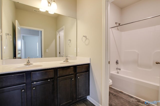 13971 Lannister Ln, Athens, AL 35613 - full bathroom with wood finished floors, toilet, double vanity, washtub / shower combination, and baseboards
