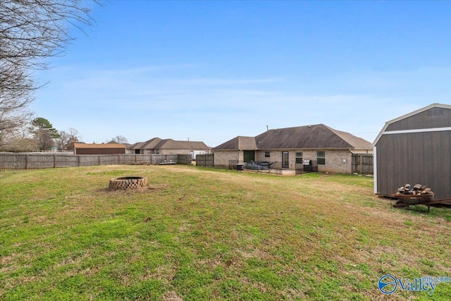 view of yard featuring a storage shed and an outdoor fire pit