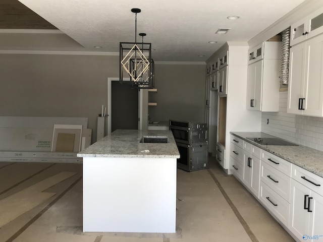 kitchen featuring a kitchen island, white cabinets, and light stone counters