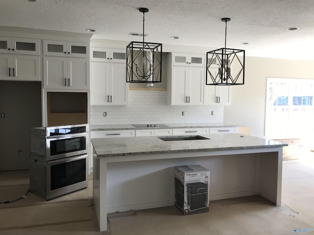 kitchen with light stone countertops, white cabinets, and a kitchen island