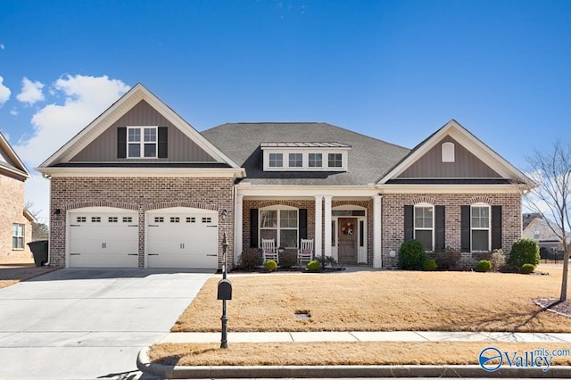 craftsman house featuring covered porch, brick siding, and concrete driveway