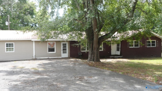 view of front of home featuring crawl space, metal roof, and brick siding