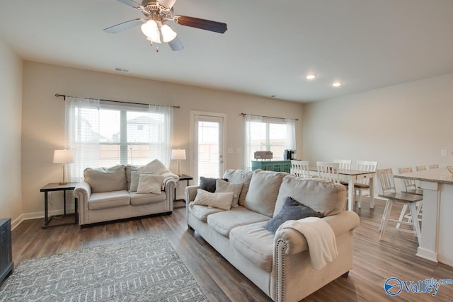 living room featuring dark hardwood / wood-style floors and ceiling fan