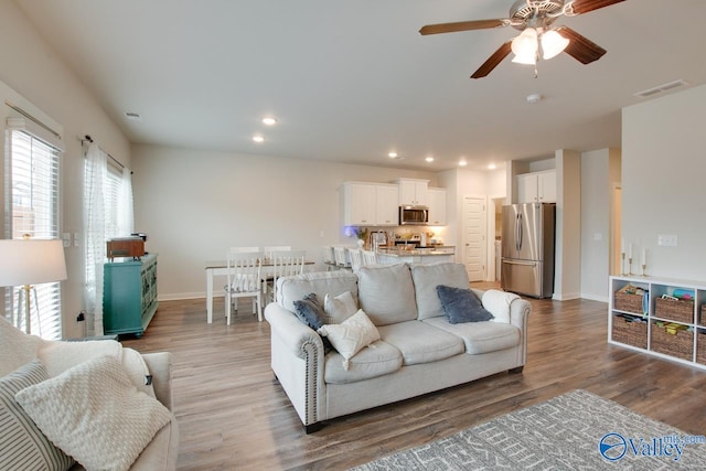 living room featuring ceiling fan and light hardwood / wood-style floors